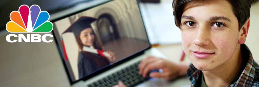Graduating senior looking at camera with laptop screen showing grad with CNBC logo on top left